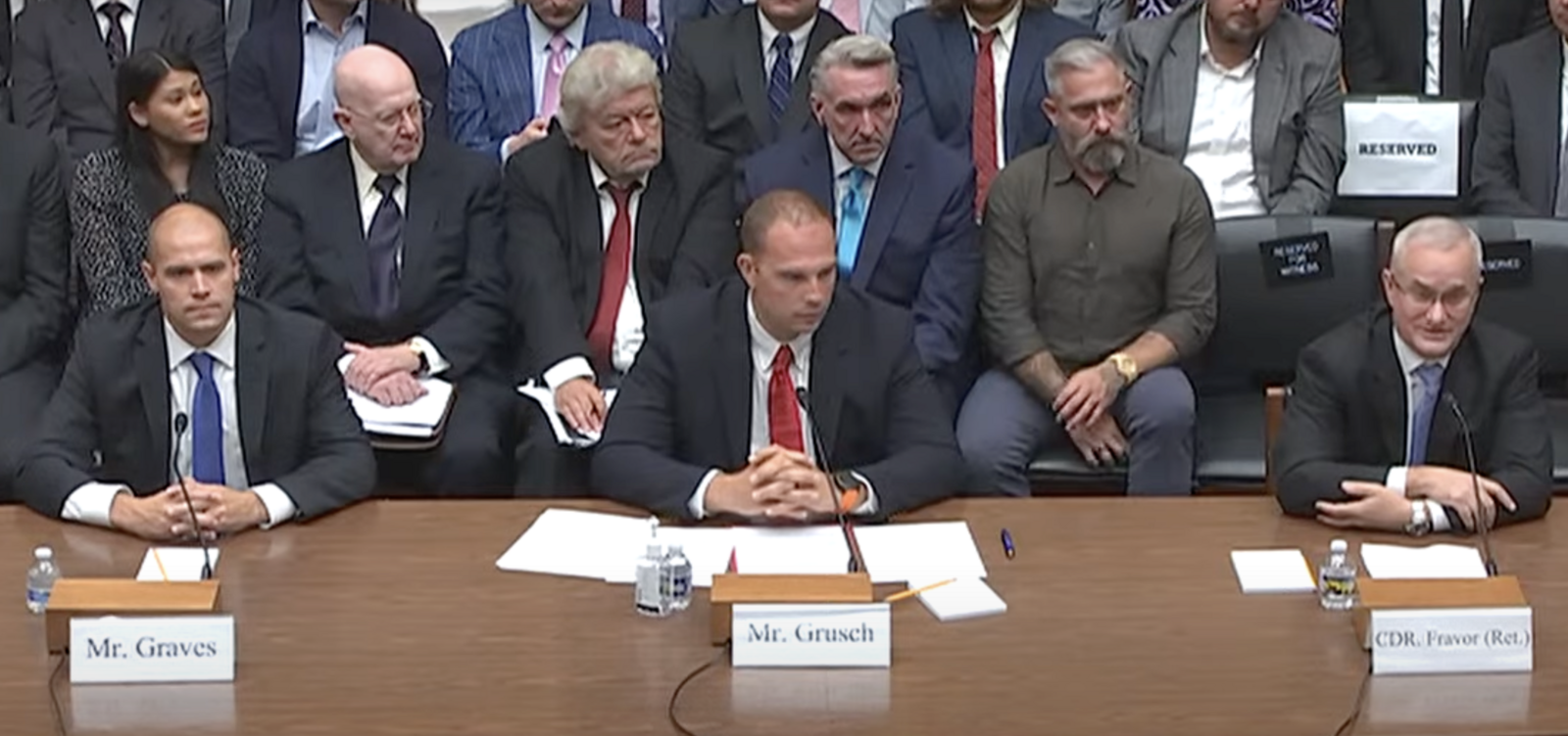 Three witnesses seated side by side at a congressional witness table: Ryan Graves, David Grusch and David Fravor