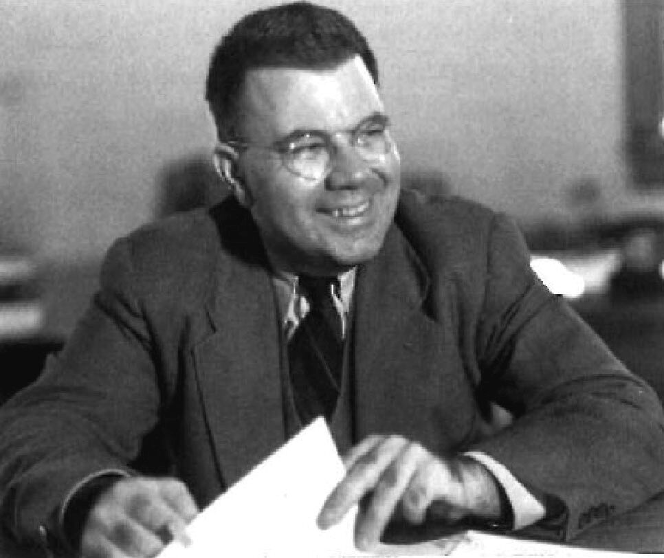 Black and white portrait photograph of physicist Edward Uhler Condon, wearing a suit and smiling