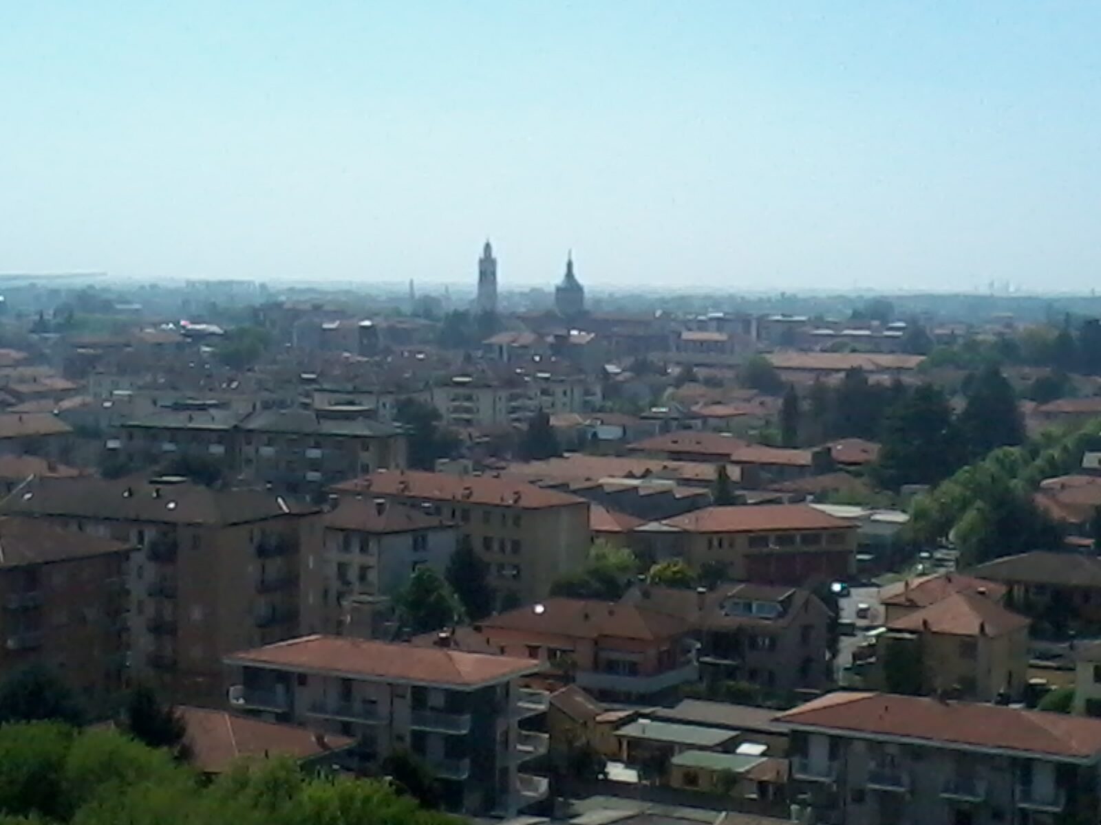 Rooftops and church towers of the town of Magenta, Lombardy, seen across the town under a clear sky