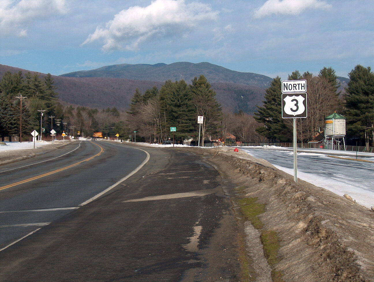 US Route 3 highway shield sign beside the road in Lincoln, New Hampshire.